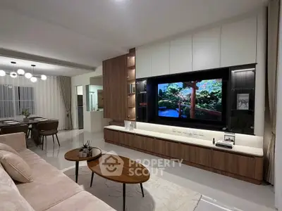 Modern living room with sleek furniture and large TV, open layout design