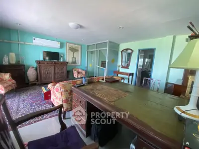 Spacious living room with vintage furniture and air conditioning, perfect for relaxation and entertaining.