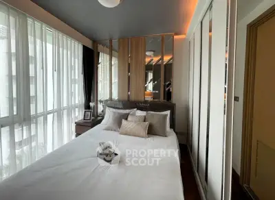 Modern bedroom with large windows and stylish decor in a luxury apartment.