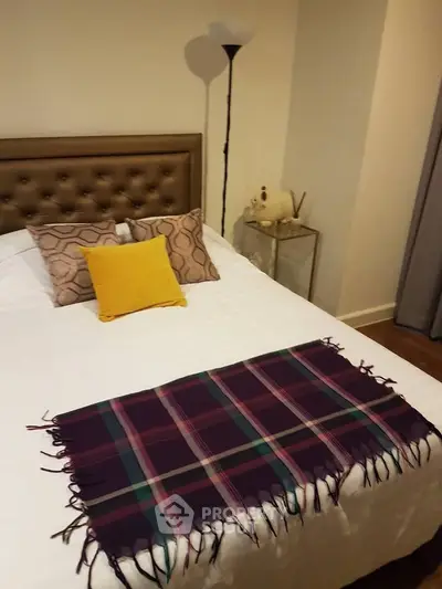 Cozy bedroom with stylish decor and plush bedding in modern apartment.