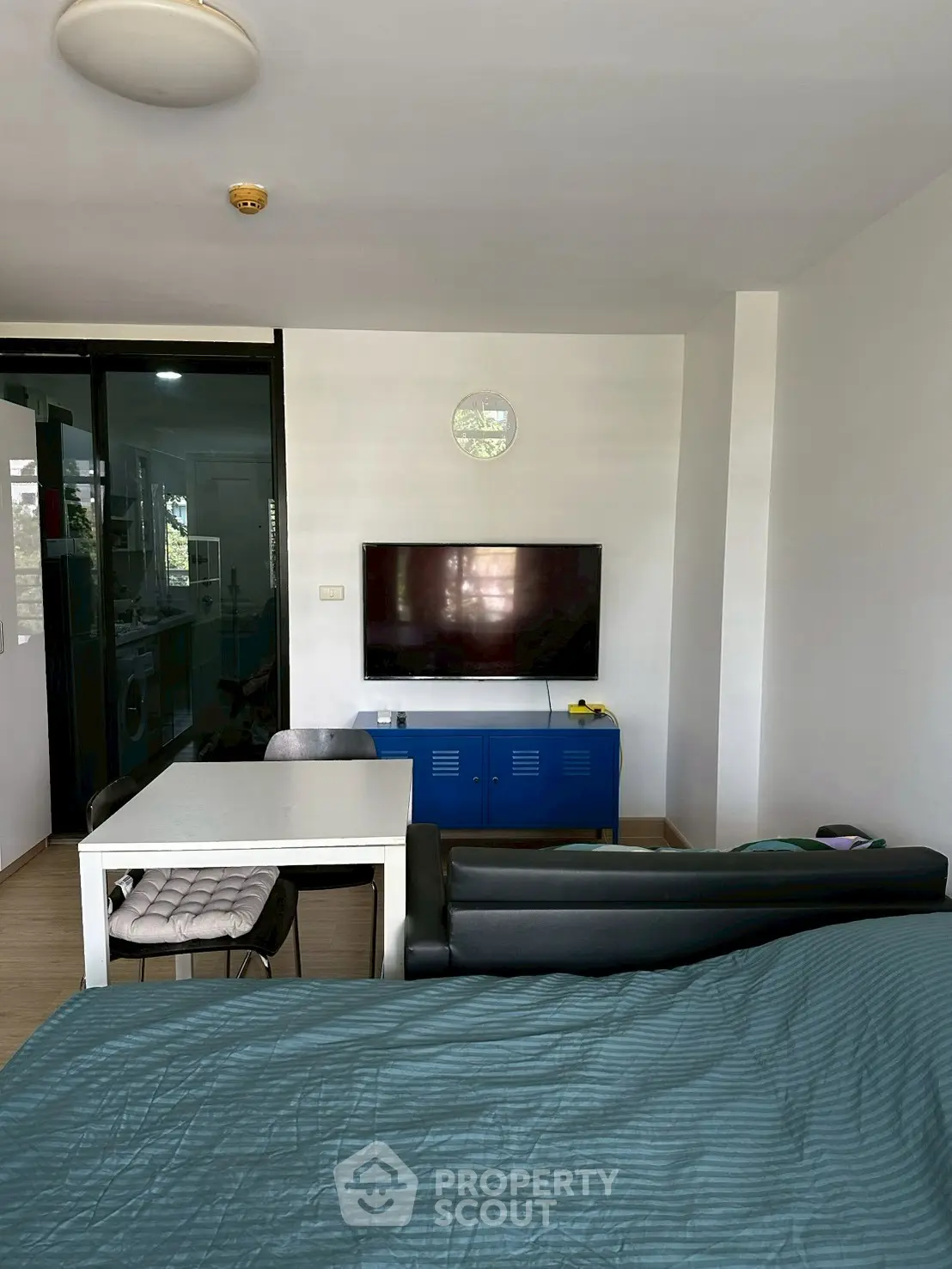 Modern living room with sleek furniture and wall-mounted TV, open layout design.