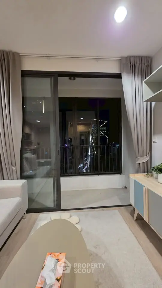 Modern living room with balcony view of city skyline at night
