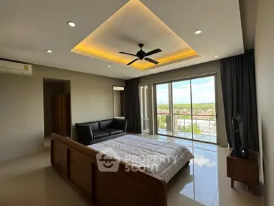 Spacious bedroom with modern ceiling fan and large windows offering scenic views.