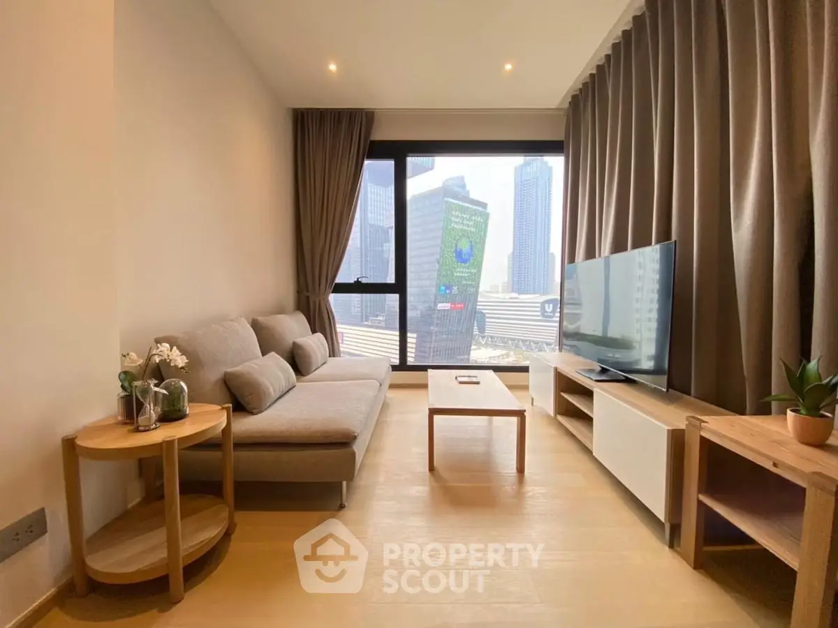 Modern living room with city view, featuring sleek furniture and large windows.