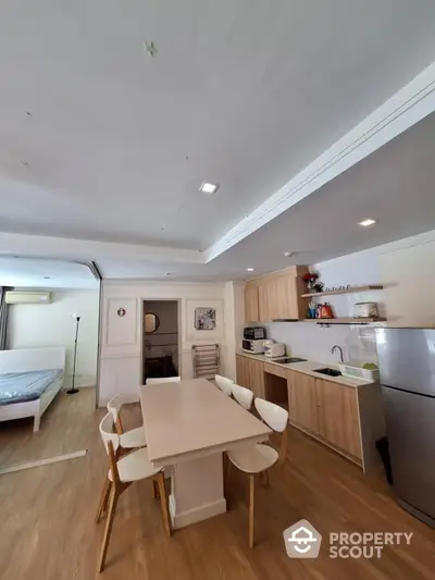 Modern open-plan kitchen and dining area with wooden flooring and sleek appliances