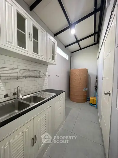 Modern kitchen with sleek cabinetry and dual sink in compact layout