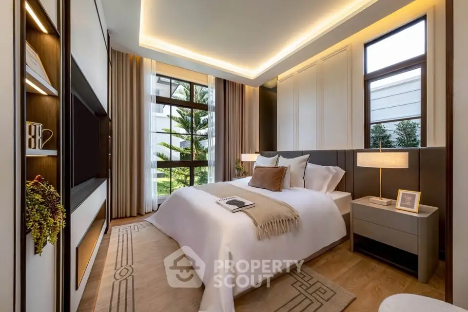 Luxurious modern bedroom with elegant decor and large windows offering a serene garden view.