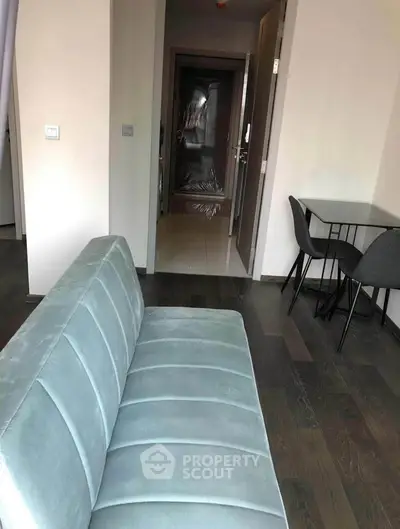 Modern apartment interior with stylish sofa and dining area, showcasing sleek design and cozy ambiance.