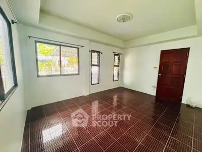 Spacious empty room with tiled flooring and large windows for natural light.