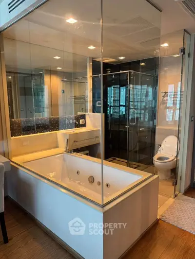 Luxurious bathroom with glass-enclosed bathtub and modern fixtures in high-end apartment.