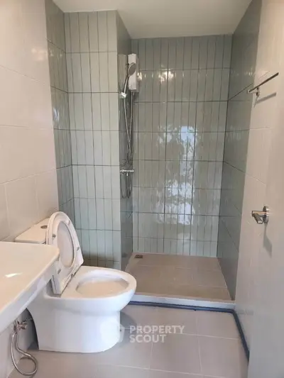 Modern bathroom with sleek shower and toilet in contemporary design.