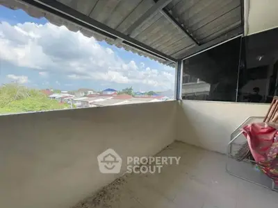 Spacious balcony with scenic view of rooftops and clear blue sky.