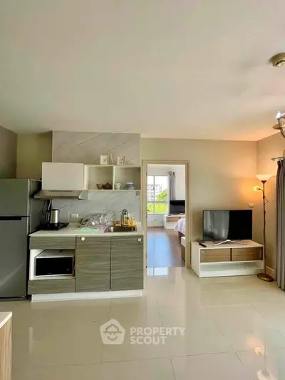 Modern open-layout kitchen and living room with sleek appliances and stylish decor.
