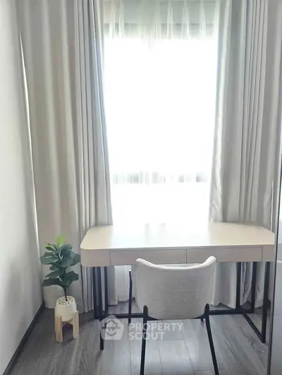 Modern study room with sleek desk, chair, and potted plant by a bright window.