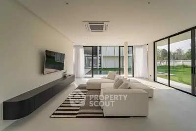 Spacious modern living room with large windows and sleek furniture, offering a bright and airy ambiance.