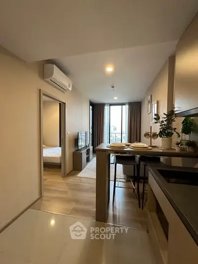 Modern open-plan living room with kitchen and balcony view in stylish apartment.