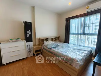 Spacious bedroom with modern furnishings and large window offering natural light.