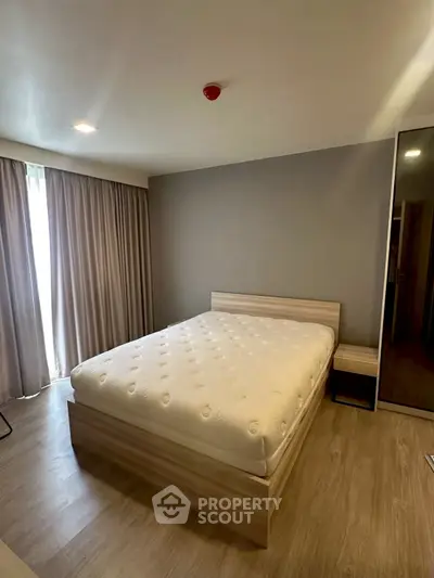 Spacious bedroom with modern decor and natural light, featuring a comfortable bed and stylish furnishings.