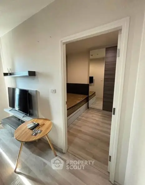 Modern apartment interior with sleek TV setup and cozy bedroom view.
