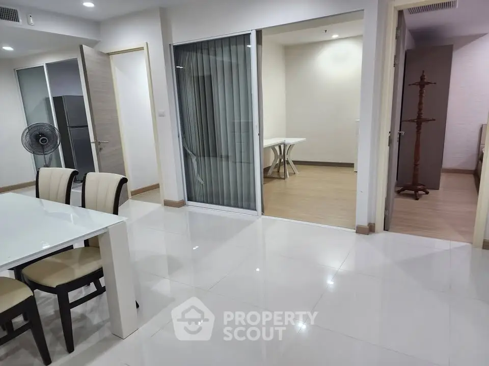 Spacious modern apartment with open layout and elegant dining area, featuring sleek white flooring and contemporary furniture.