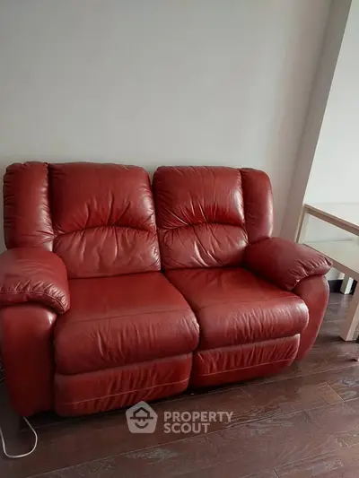 Luxurious red leather sofa in a stylish living room setting with wooden flooring.