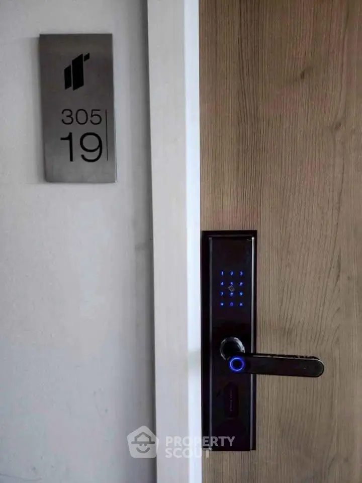 Modern apartment door with electronic lock and room number 305, showcasing secure living.