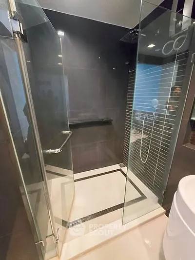 Modern bathroom with sleek glass shower enclosure and contemporary design.