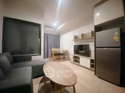 Modern living room with sleek furniture and open layout, featuring a cozy sofa and dining area.