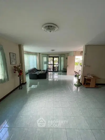 Spacious living room with large windows and natural light, ideal for family gatherings.