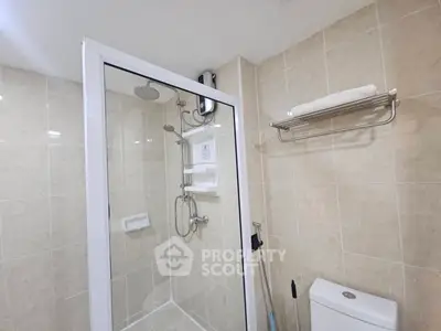 Modern bathroom with glass shower enclosure and tiled walls