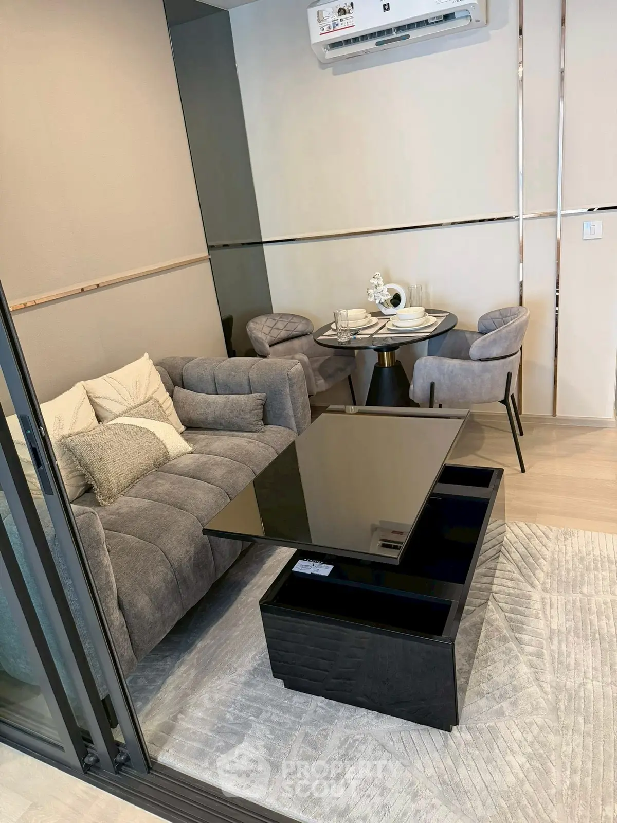 Modern living room with sleek furniture and dining area, featuring a stylish sofa and elegant table setting.