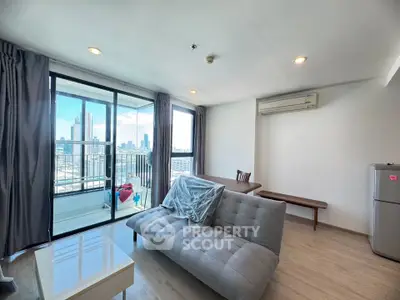 Modern living room with city view and balcony access in a high-rise apartment.