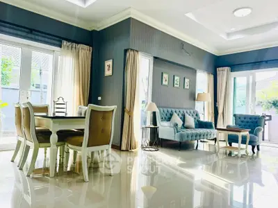 Elegant living room with plush seating and dining area, featuring large windows and natural light.