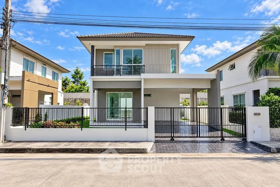 Modern two-story house with sleek design and spacious driveway in a suburban neighborhood.