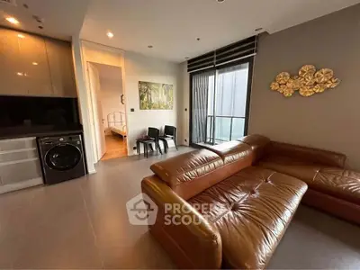 Modern living room with leather sofa and washing machine in sleek apartment