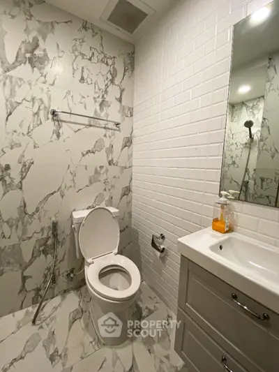 Modern bathroom with marble tiles and sleek white fixtures