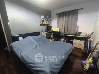 Cozy bedroom with modern decor, featuring a comfortable bed, musical instruments, and a stylish workspace.