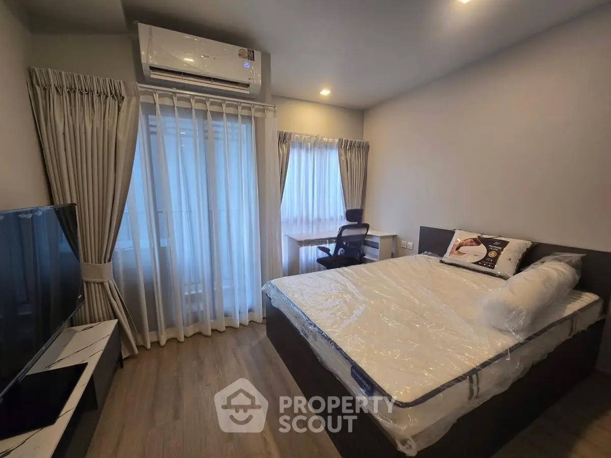Modern bedroom with large window, air conditioning, and sleek furnishings in a stylish apartment.