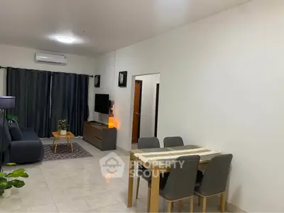 Modern living room with dining area, featuring sleek furniture and stylish decor.