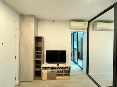 Modern living room with sleek TV stand and mirrored wardrobe in stylish apartment.