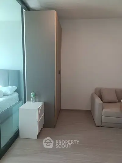 Modern bedroom with glass partition and cozy sofa