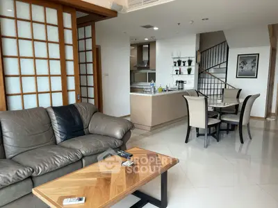 Spacious modern living room with open kitchen and stylish dining area in a contemporary apartment.