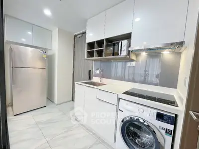 Modern kitchen with sleek appliances and washing machine in compact layout