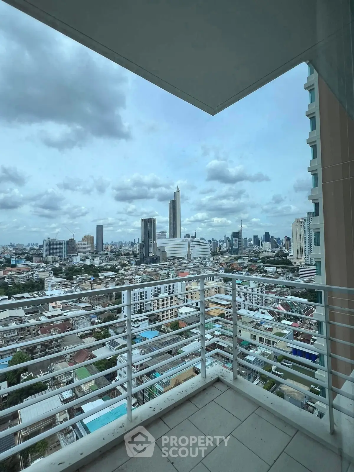 Stunning cityscape view from a high-rise balcony with modern railing.