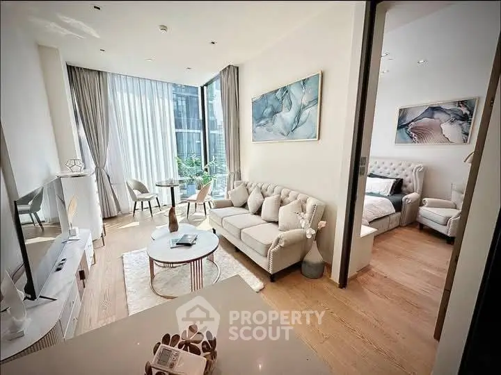 Elegant living room with natural light and stylish decor adjacent to cozy bedroom.