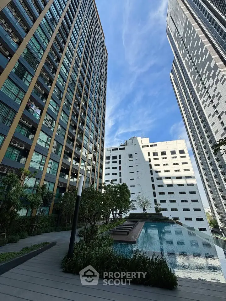 Stunning urban high-rise buildings with a serene pool and lush greenery, perfect for modern living.