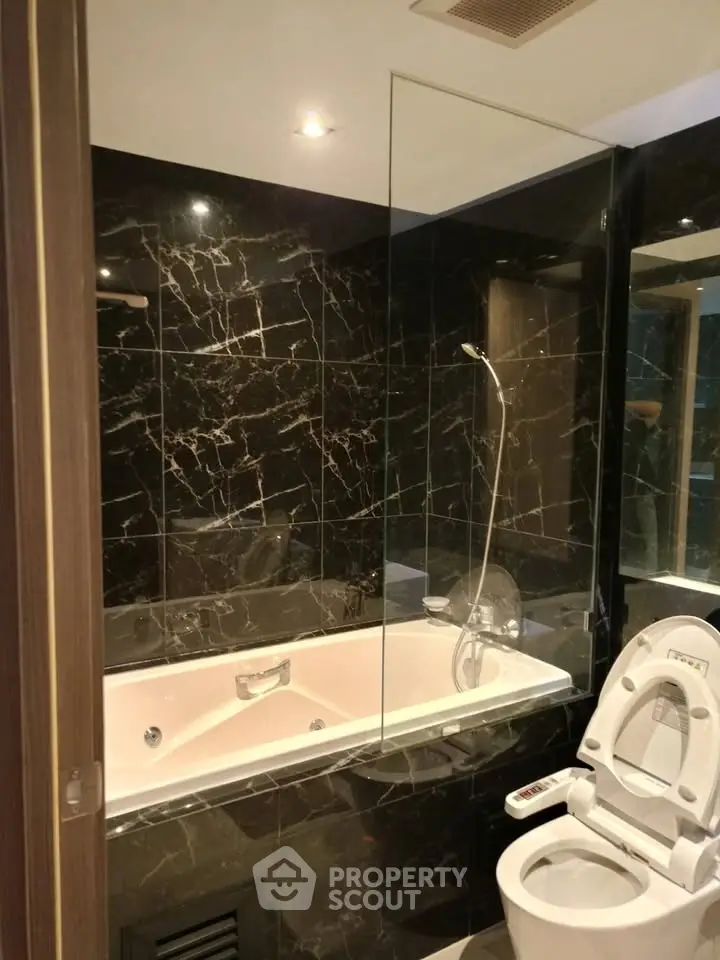 Luxurious bathroom with marble walls and modern bathtub in upscale property.