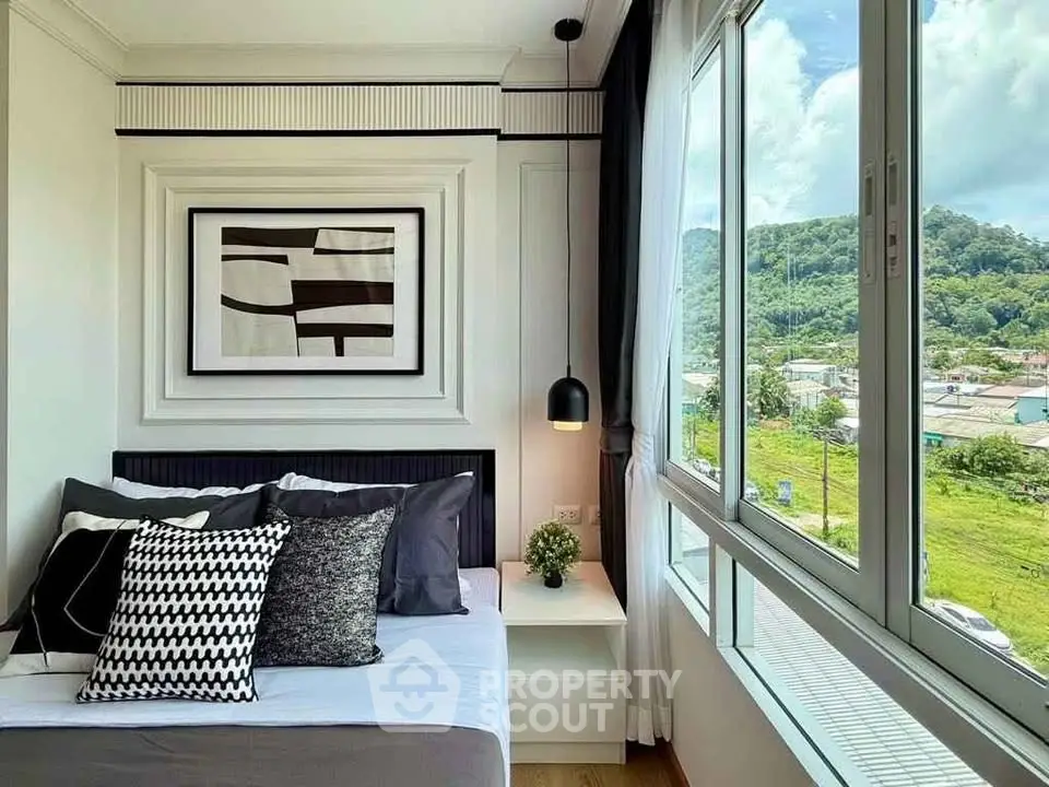 Modern bedroom with large window and scenic view, stylish decor and cozy ambiance.