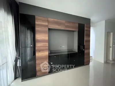 Modern living room with sleek built-in storage and large windows for natural light.