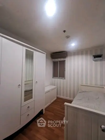 Cozy bedroom with stylish wardrobe and wooden flooring